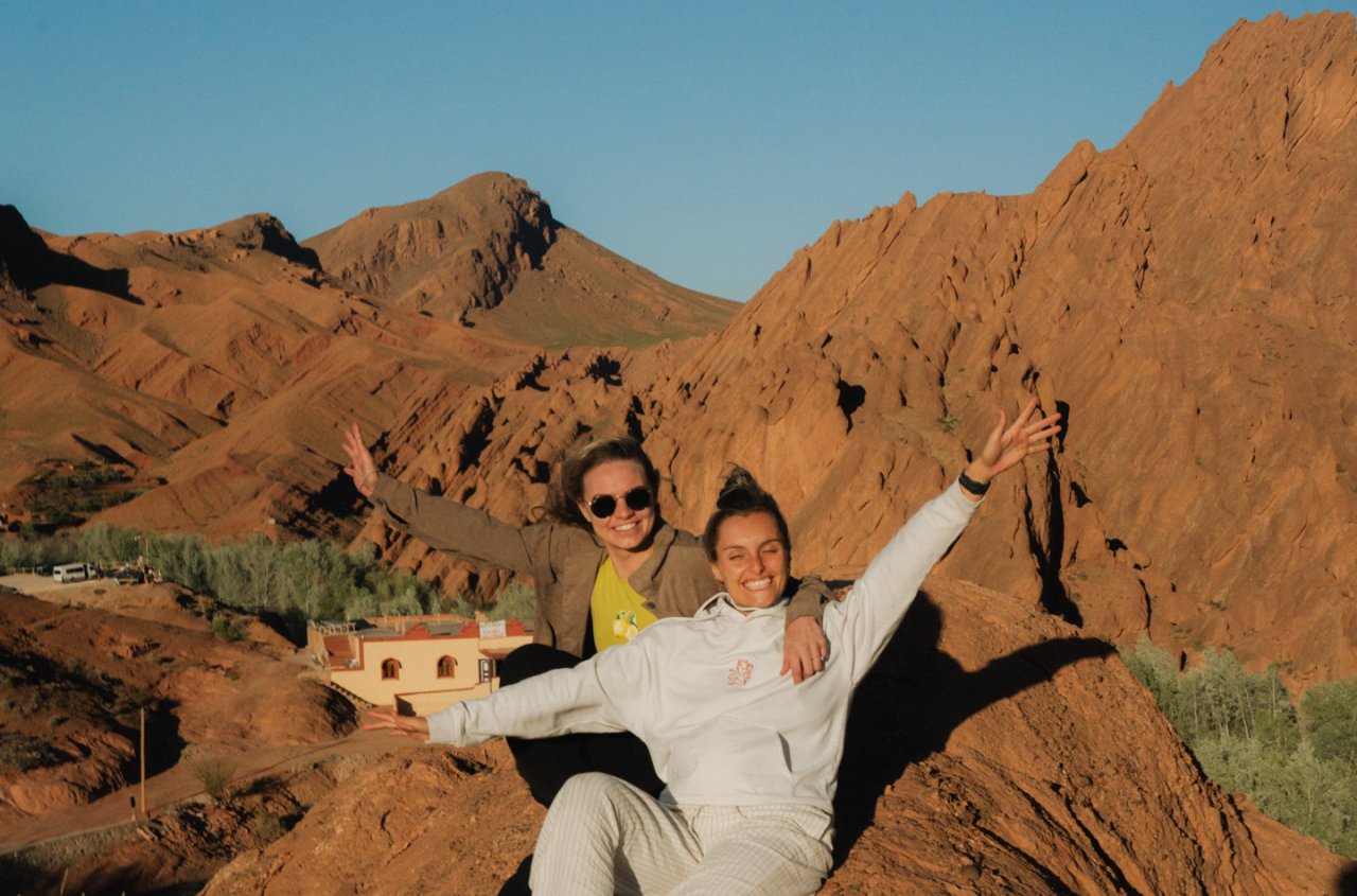 Two female travellers pose overlooking the Monkey Fingers Valley during a travel day to Dades Valley on their Morocco group tour